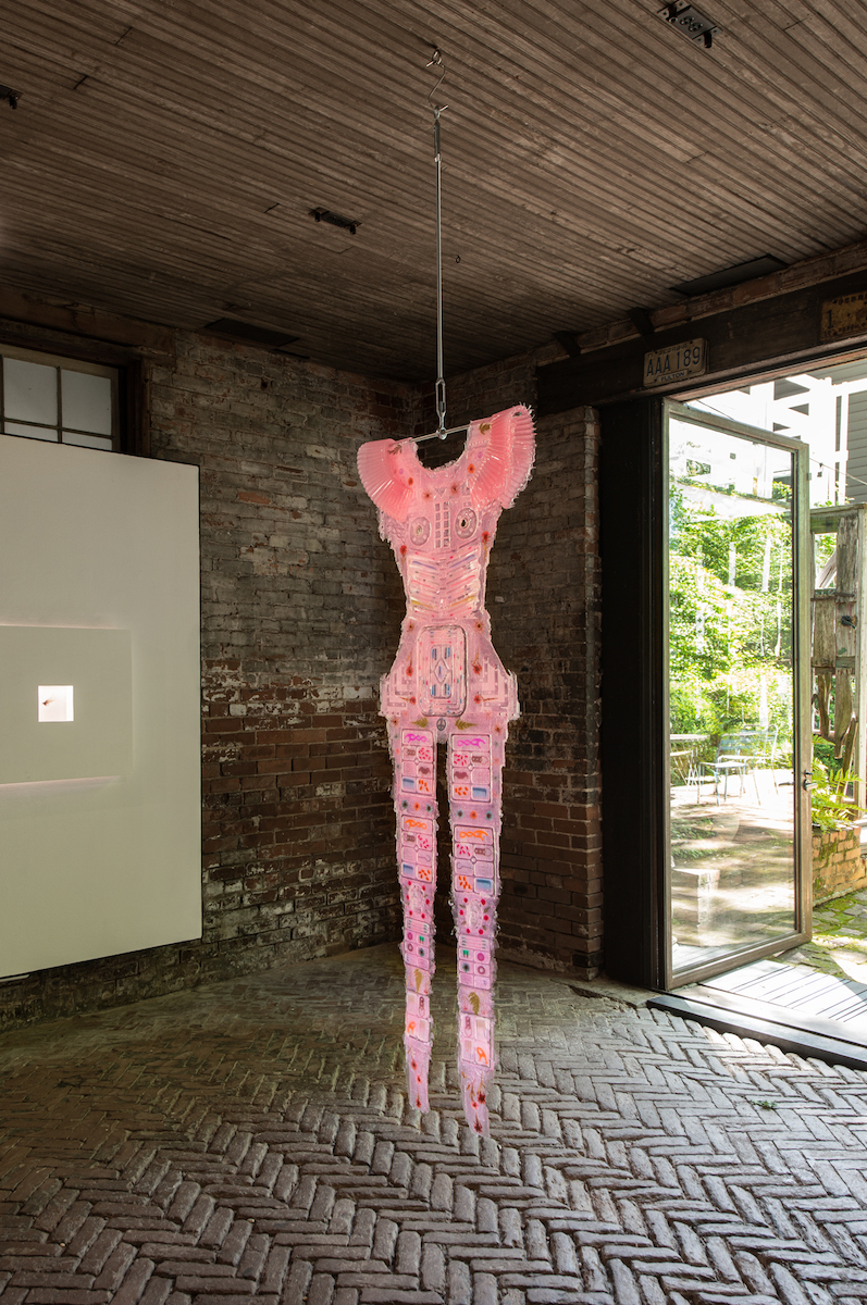 Installation view of "Is it not enough that I smile in the valleys?" featuring Amy Brener, "Flexi-Shield Jumpsuit (Rose)," 2021